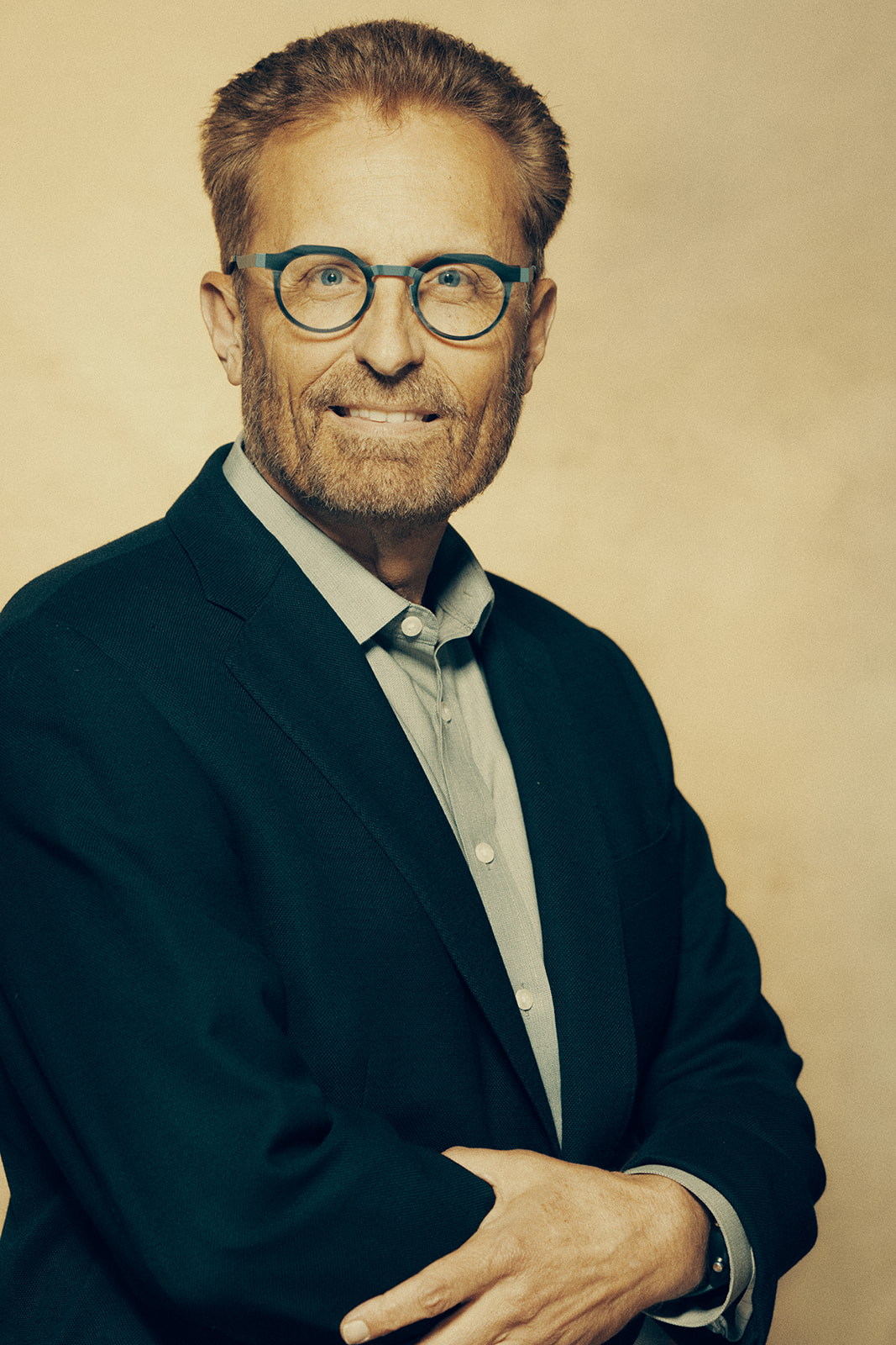 Image of Mart Green, smiling at the camera. He is wearing glasses and a dark suit.